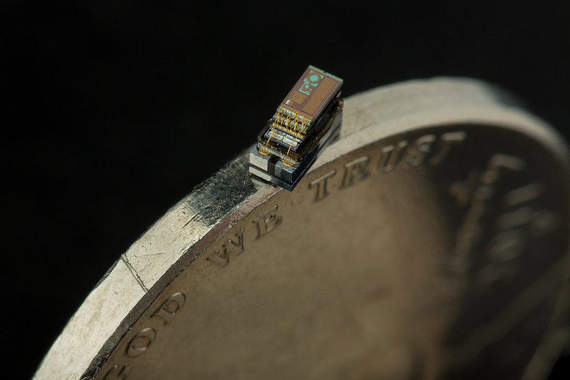 Close up photo of Michigan Micro Mote Supercomputer size next to a dime to show its small size